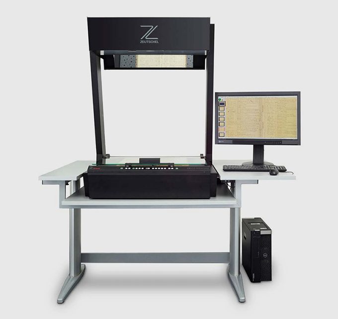 Escáner Zeutschel OS C sobre su mesa, con monitor y estación de trabajo